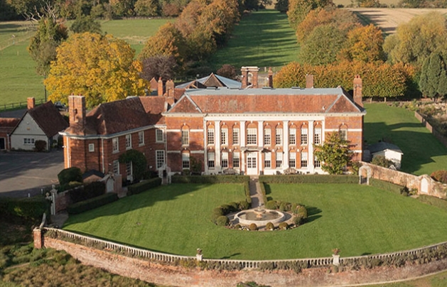 large red brick mansion with white details on facade