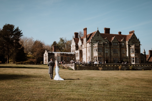 Bride and groom walking on lawn towards Balcombe Place