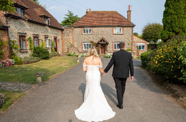 Bride and groom walking towards Selden Barns wedding venue